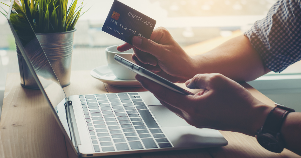 Photograph of a male purchasing something with his credit card